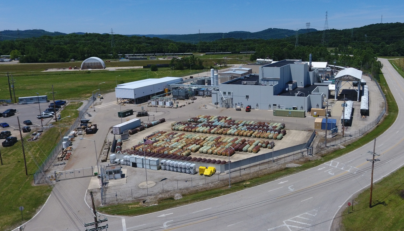 Aerial view of a large facility building with lots of canisters lined up outside of the building