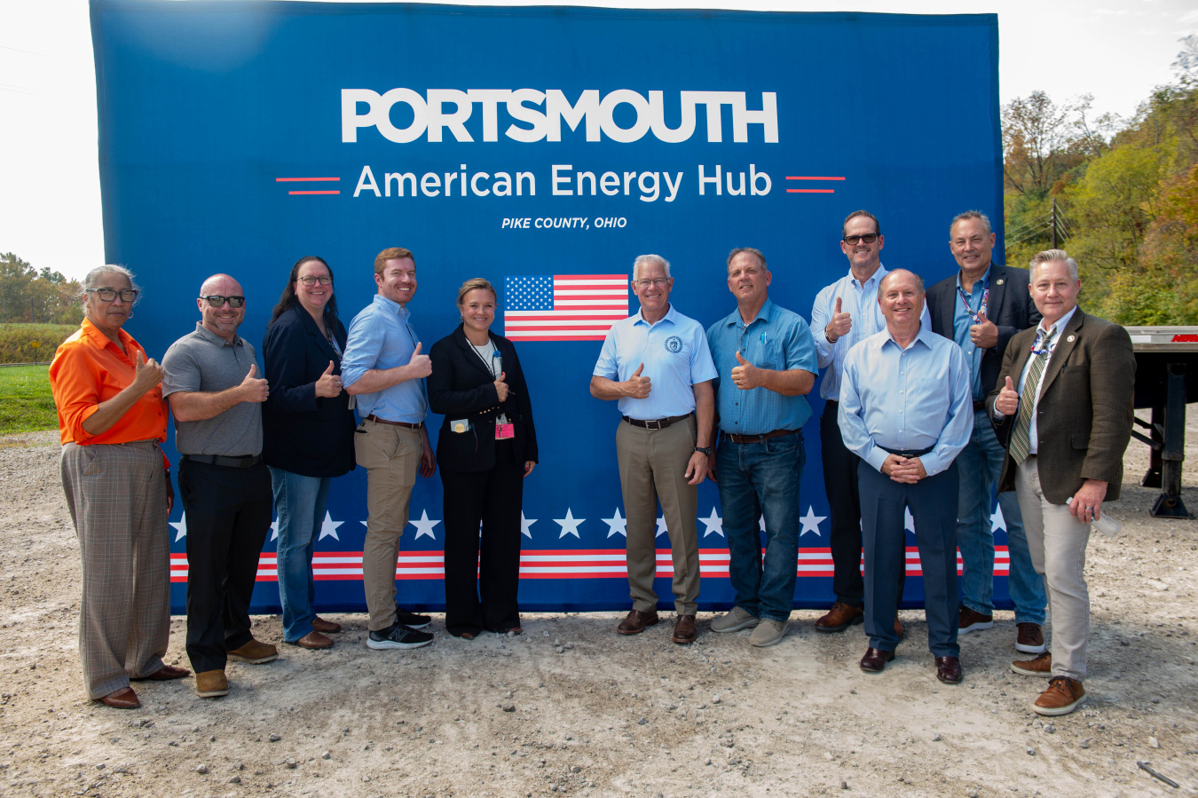 A group of professionals posing for a photo while holding a thumbs up pose