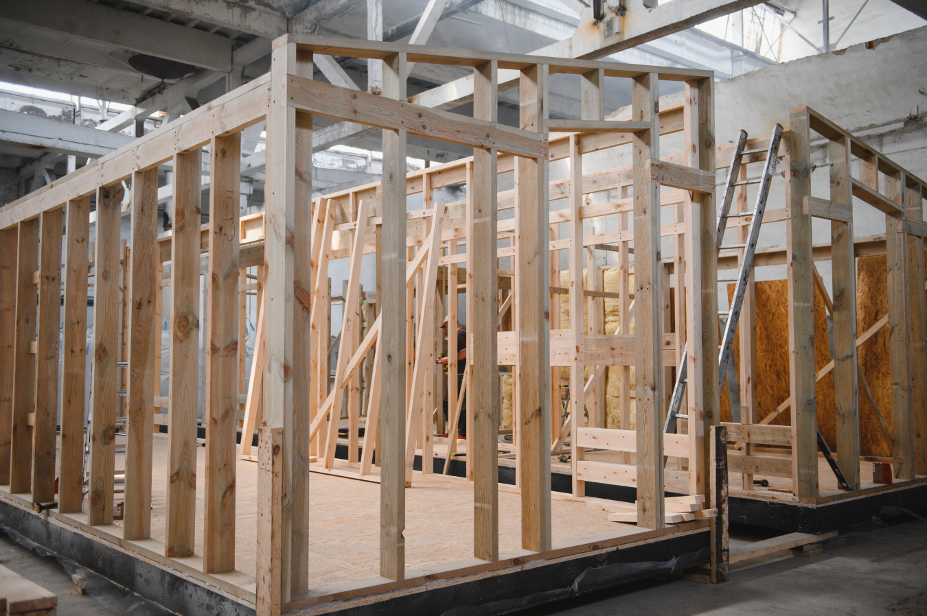 The wood frame of a house being assembled in a factory.