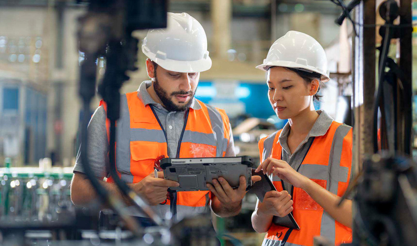 Technicians review tablet data in industrial facility