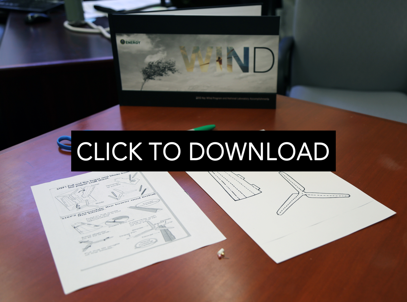 Box on a table labeled wind with two pieces of paper with computer-generated wind turbine drawings and instructions.