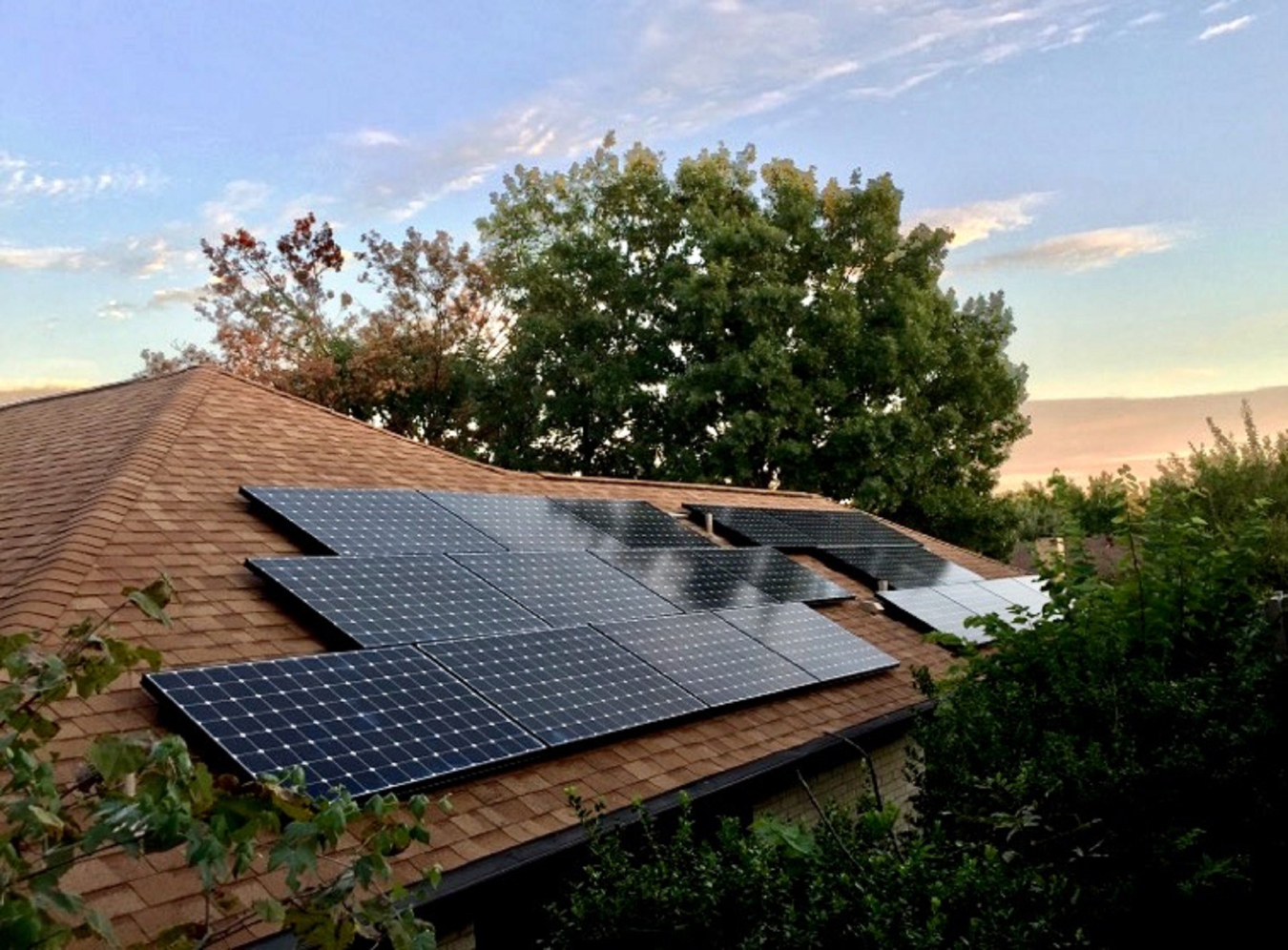 sun sets over a rooftop solar installation