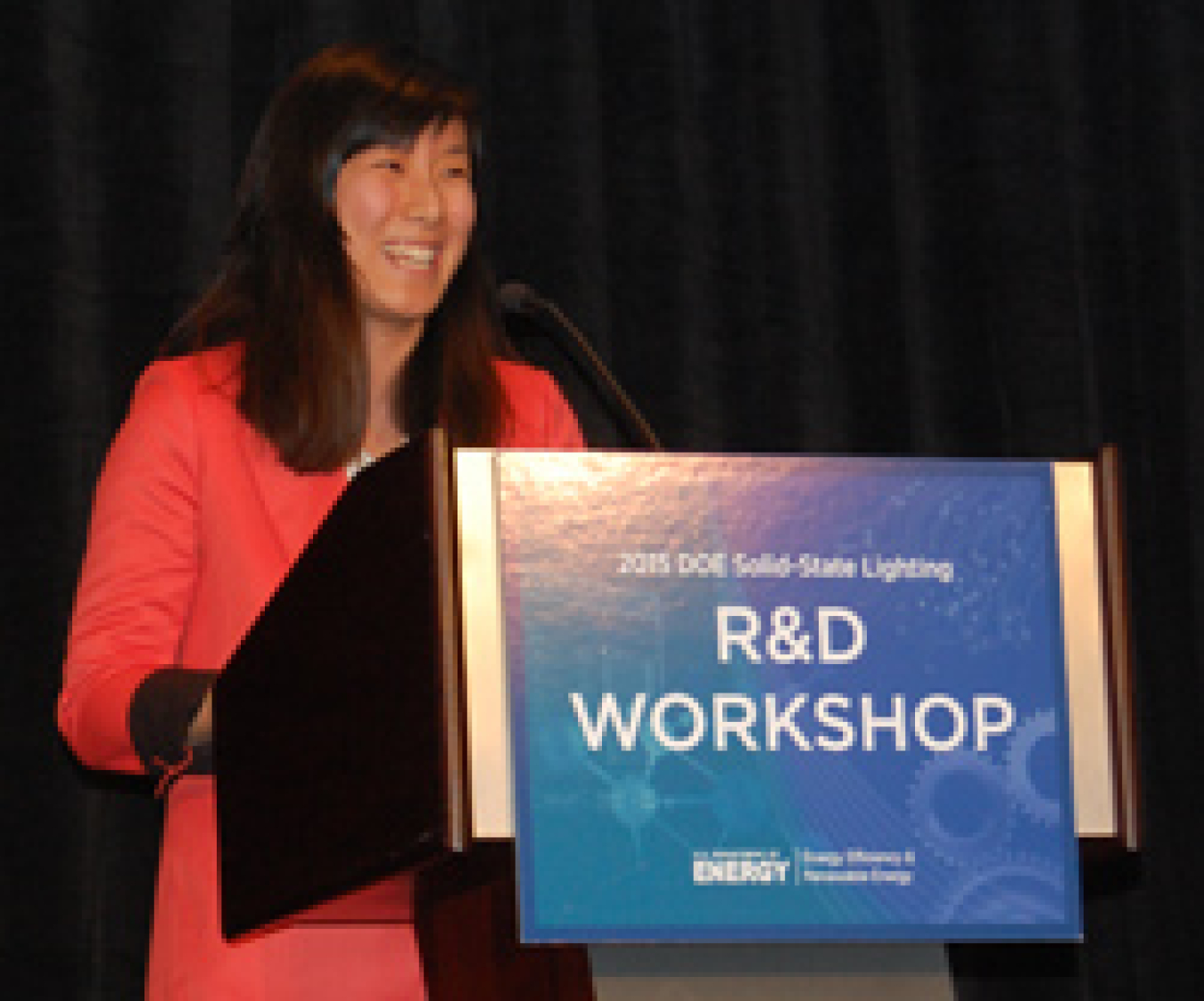 Woman standing at a lectern, addressing the conference audience.