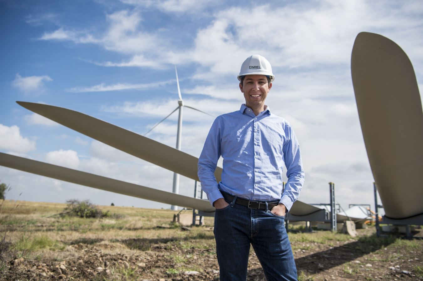 A man standing in front of wind turbines