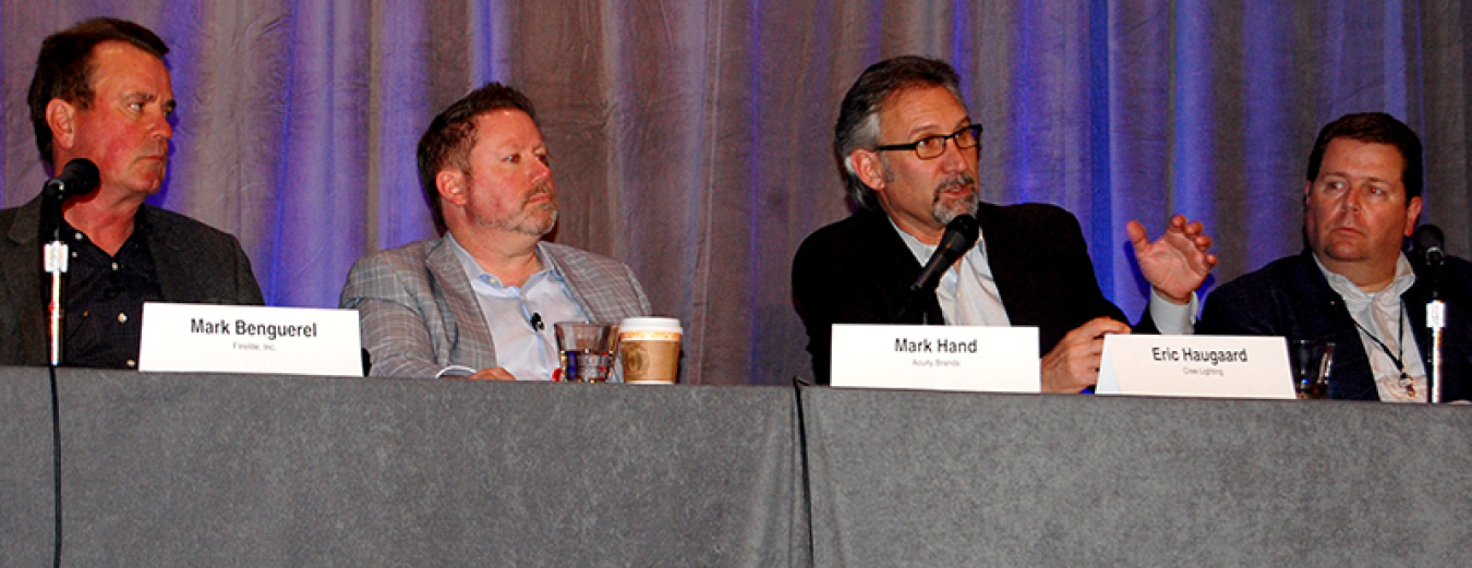 Four people sitting at a table as panelists in front of the audience.