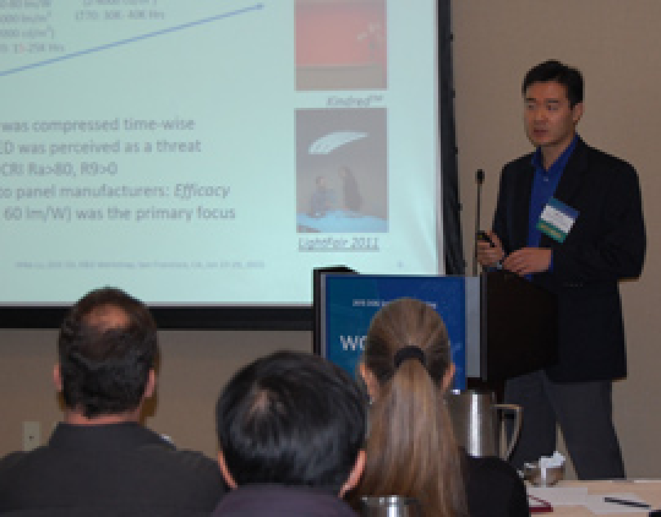 Man standing at a lectern, addressing the conference audience.