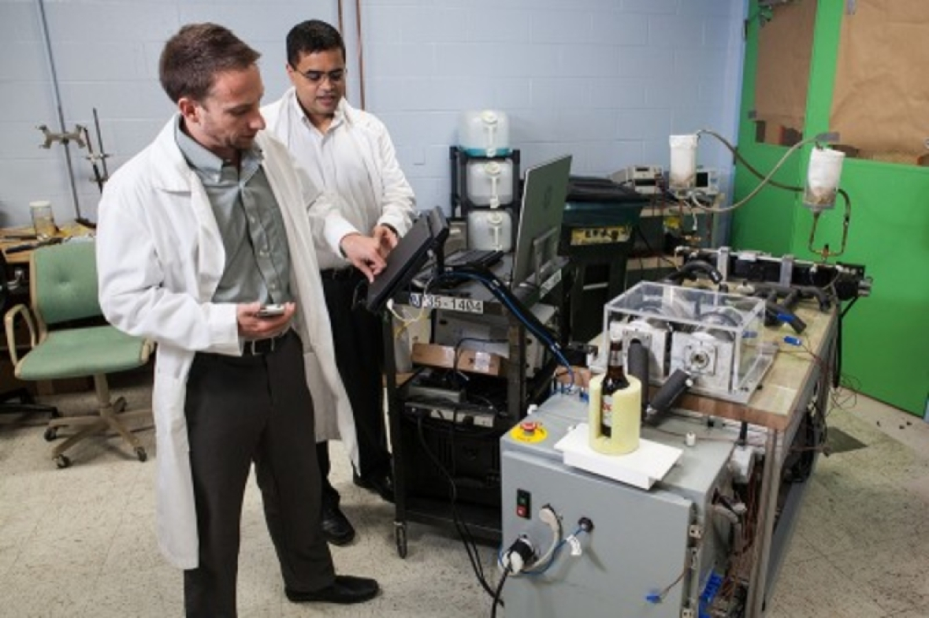 Photo of two men in lab coats working on a magnetocaloric system.