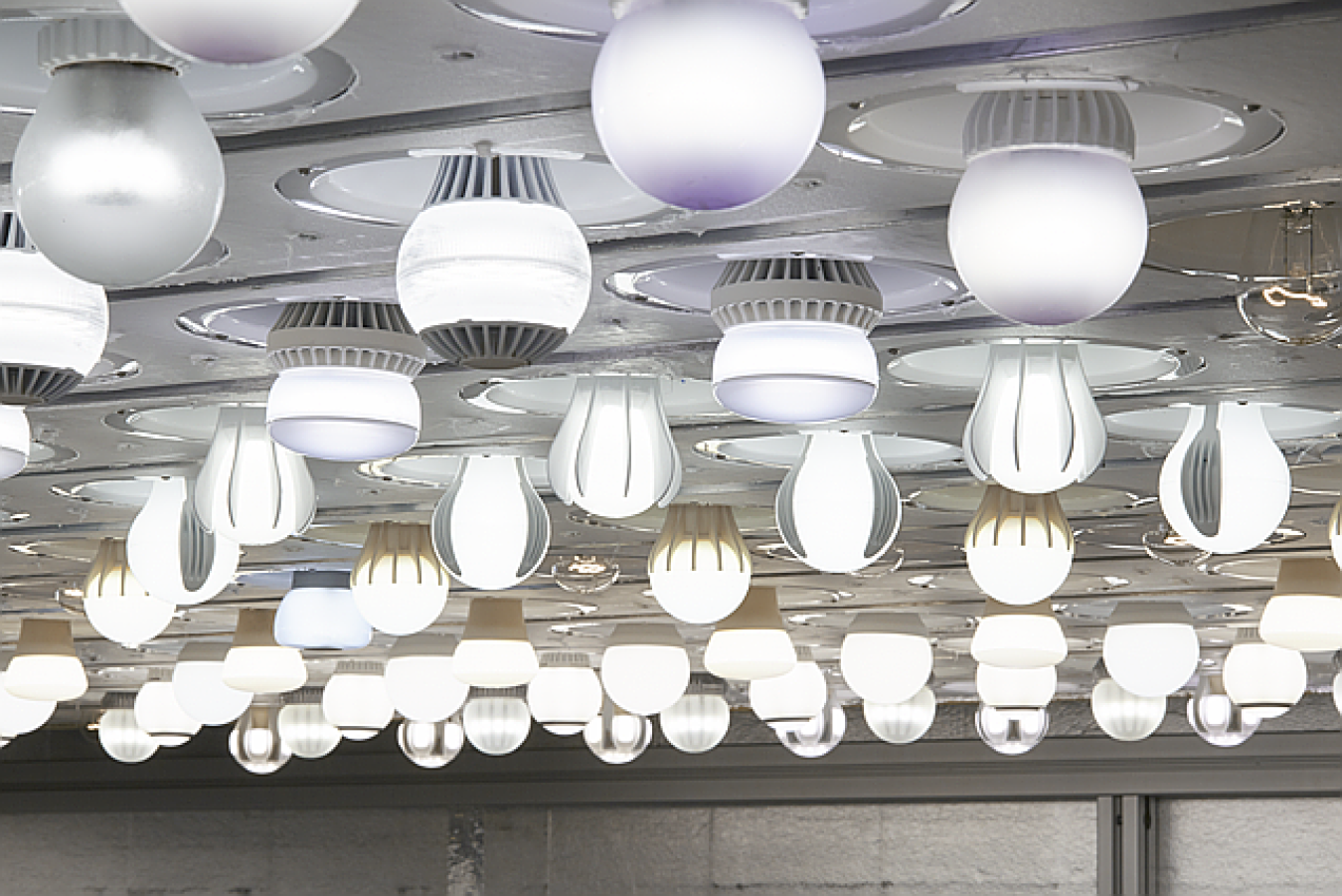 Different shapes of lighting fixtures using LED lights hang from the ceiing. 