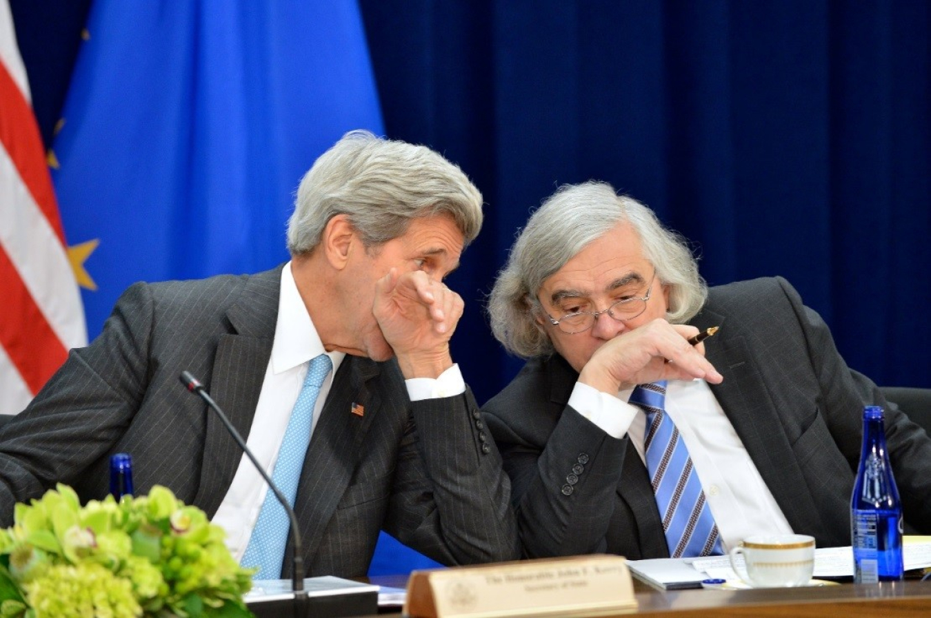 Secretary of State John Kerry and Energy Department Secretary Ernest Moniz talking at a table.