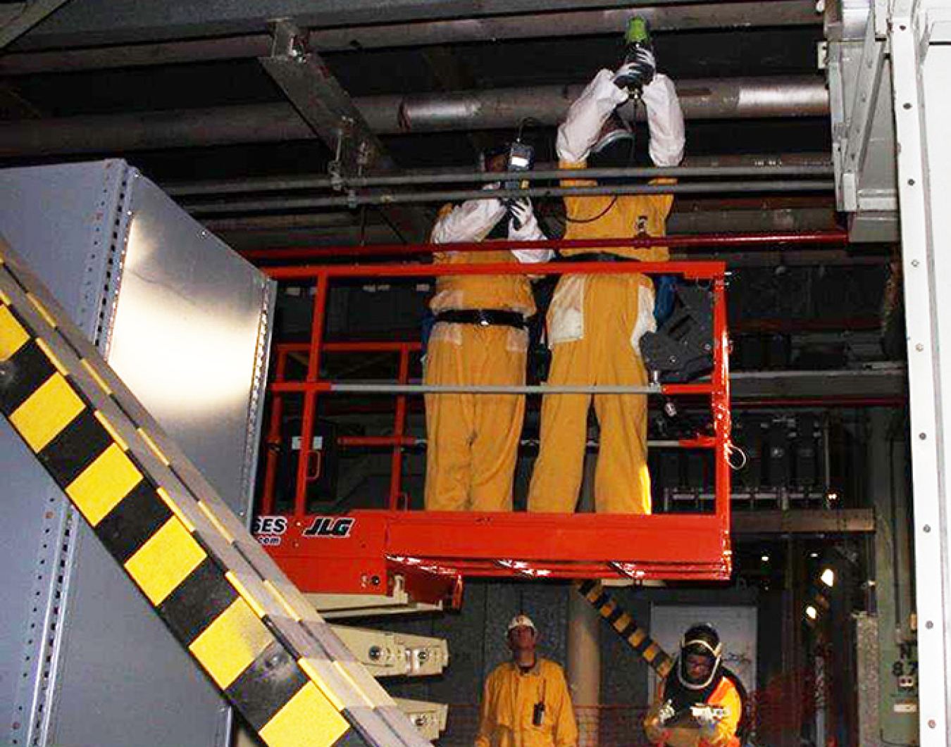 Workers assess piping in preparation for future demolition.