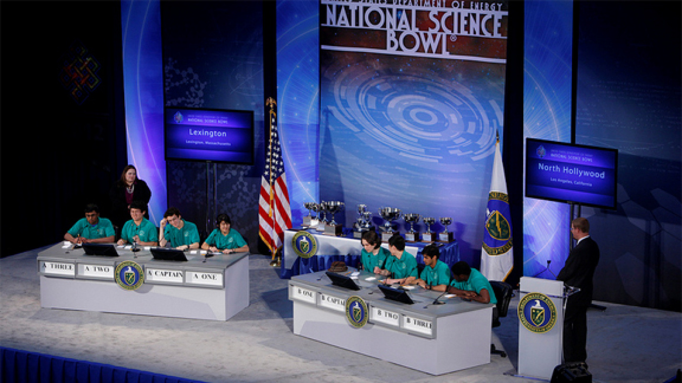 An image of 8 students on a stage participating in the National Science Bowl.