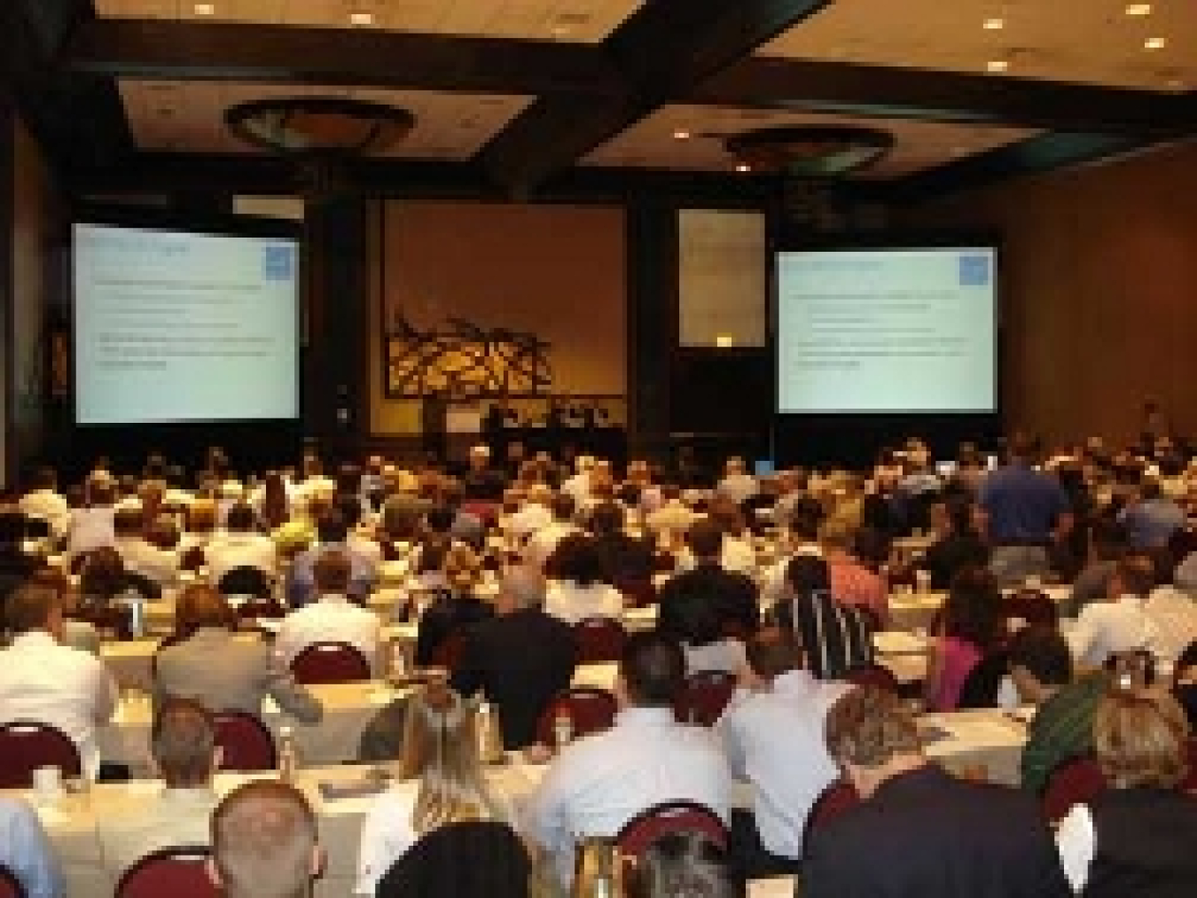 A photo of a group of attendees listening to a presentation.