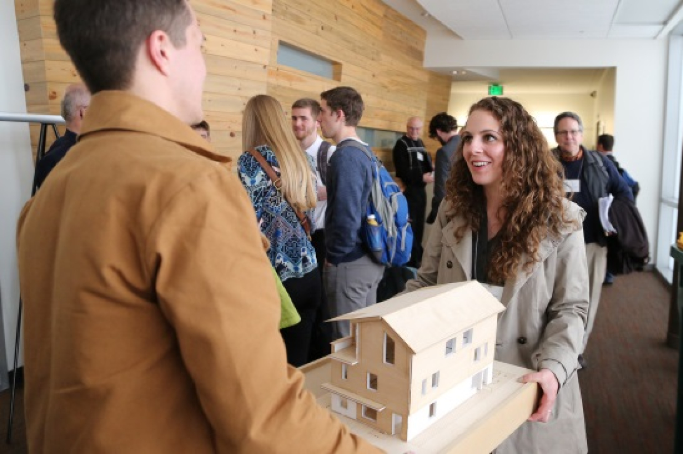 Image of students carrying a model home.