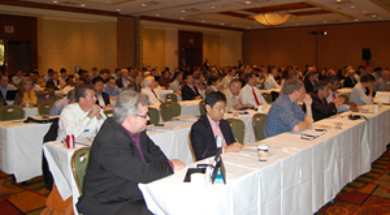 Photo of a room of people seated at conference tables.