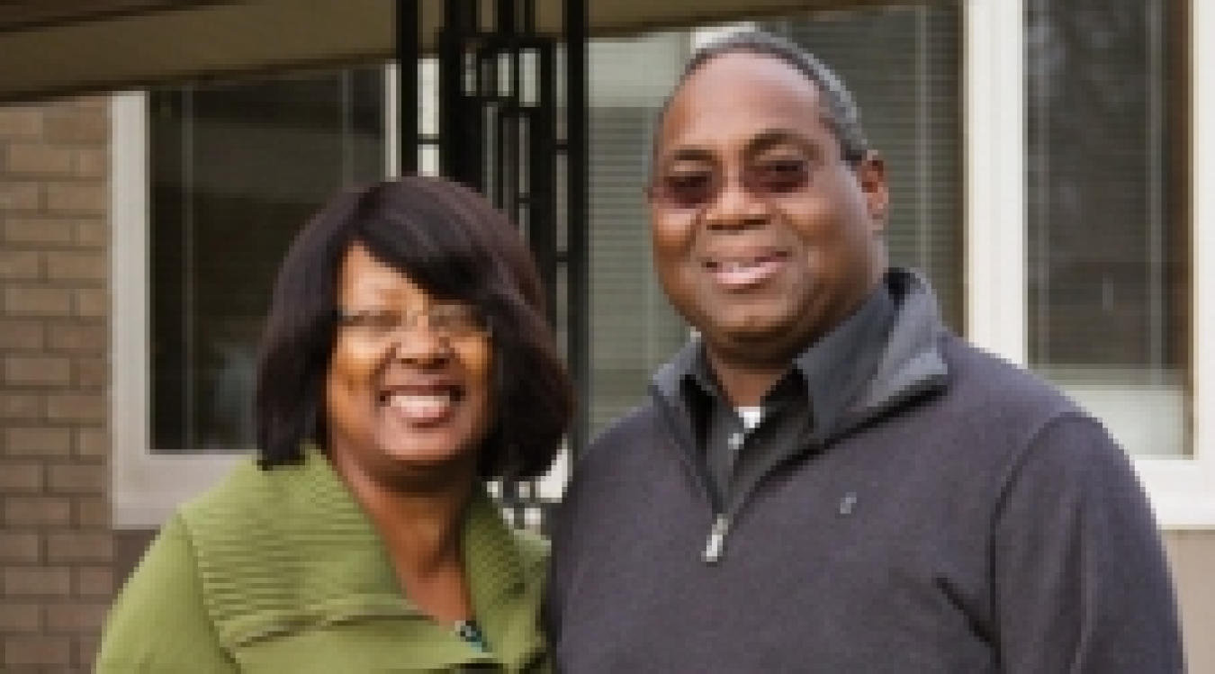 A couple -- a man and a woman -- looking at the camera and smiling.