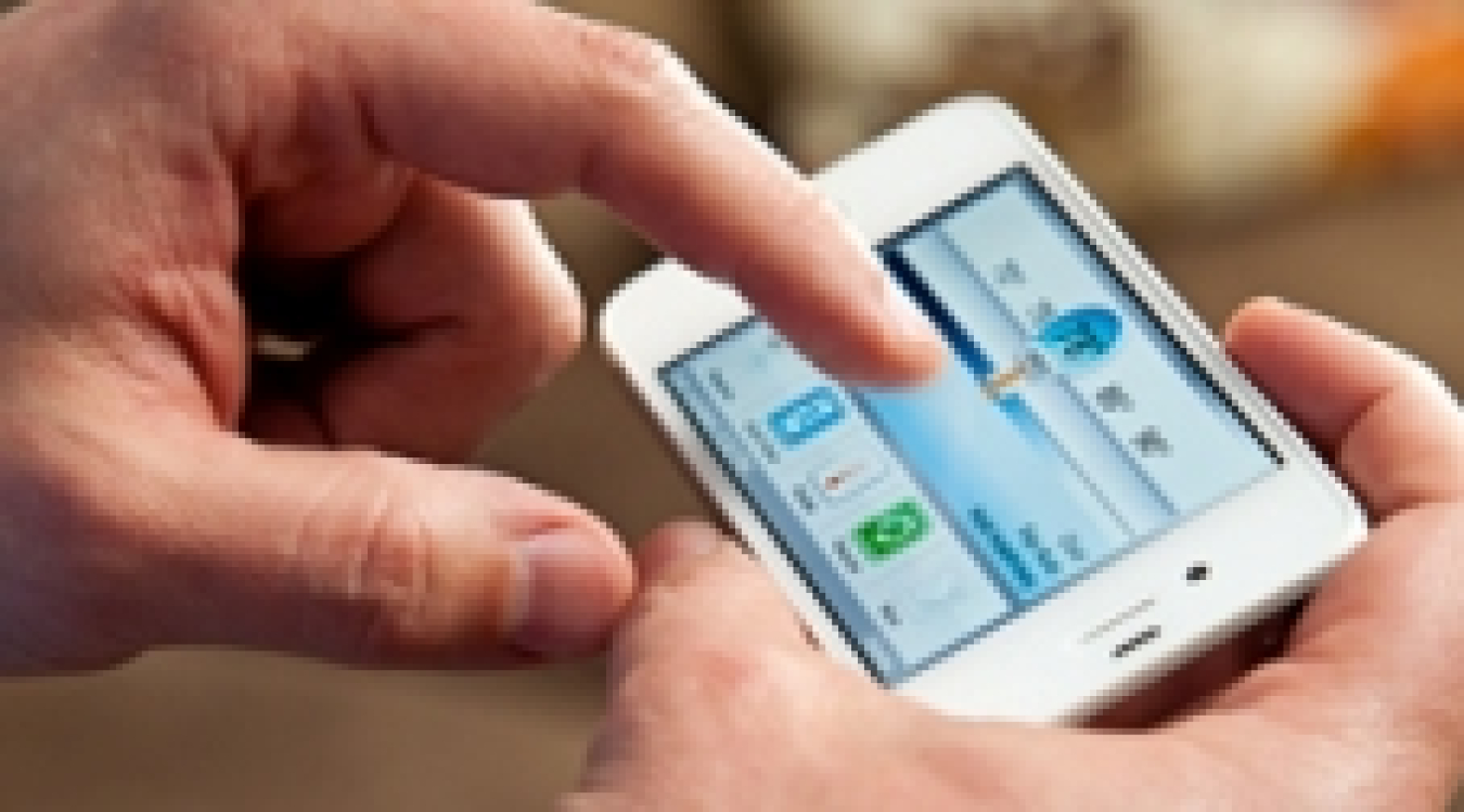 Closeup of a smart phone displaying thermostat controls, in someone's hands.