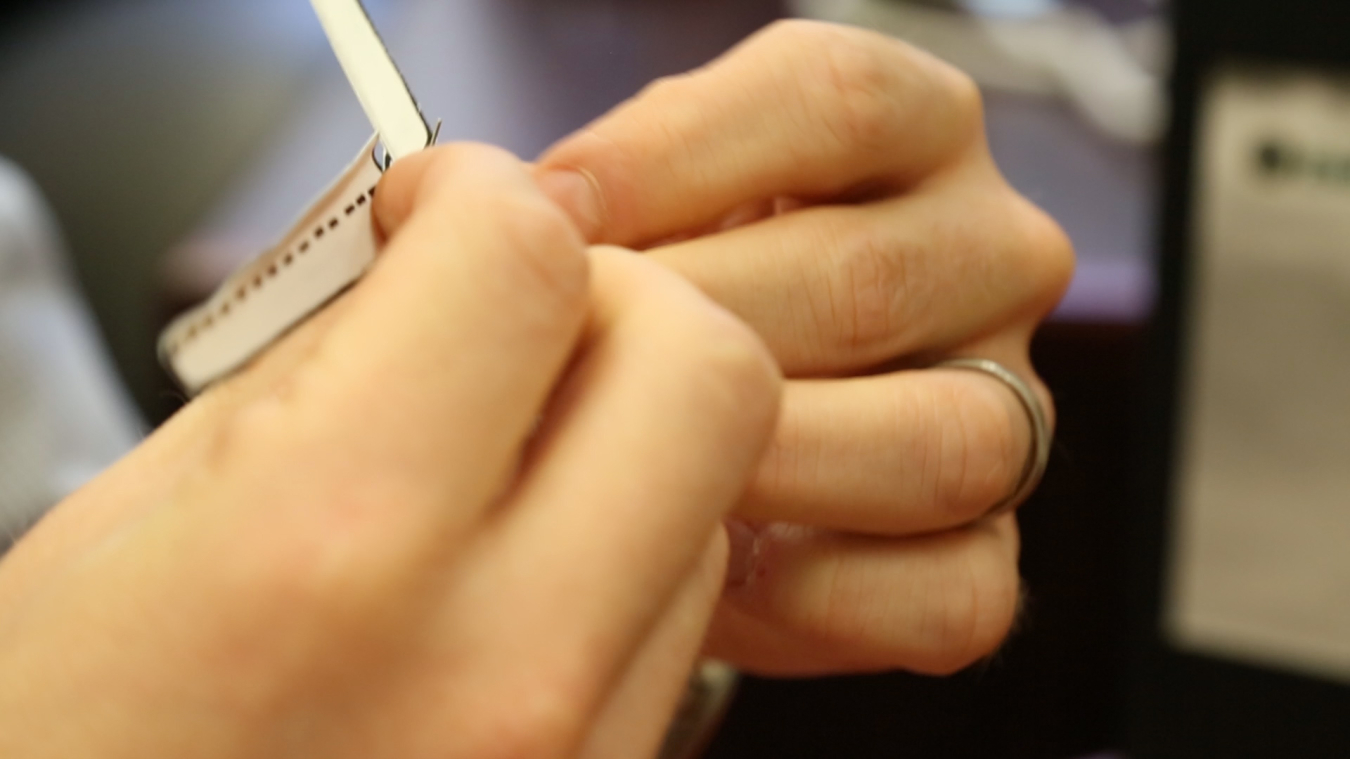 Hands slightly bend each blade along the dotted lines.