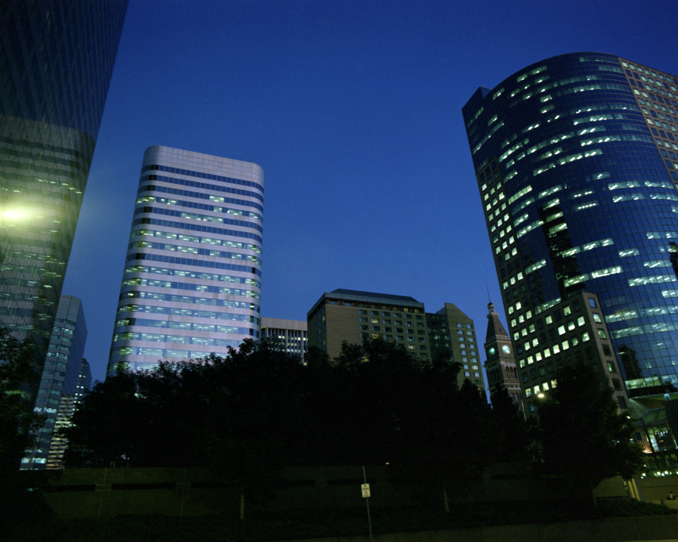 A few tall office buildings at night.