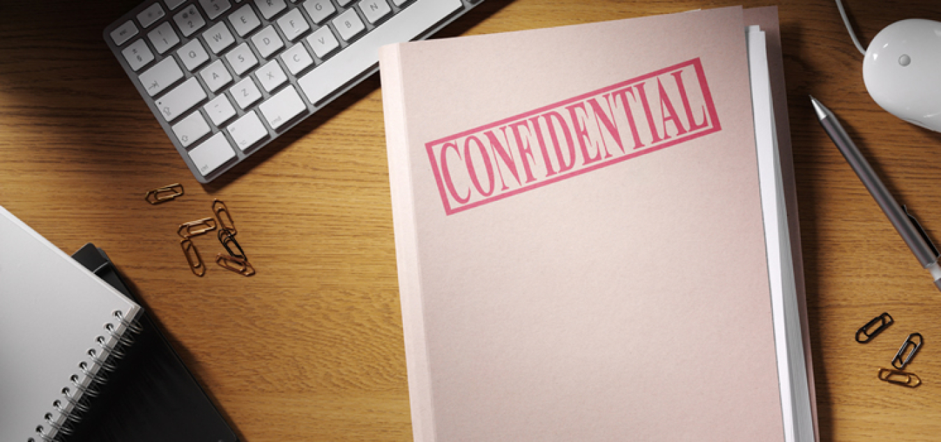 Image of keyboard and folder marked confidential.