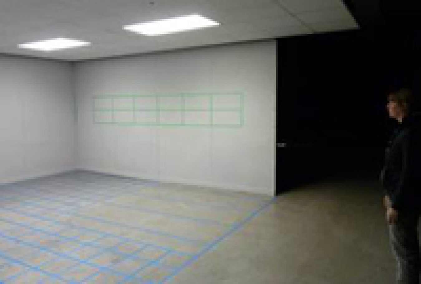 Photo of a lighting design lab space with a person standing at right.