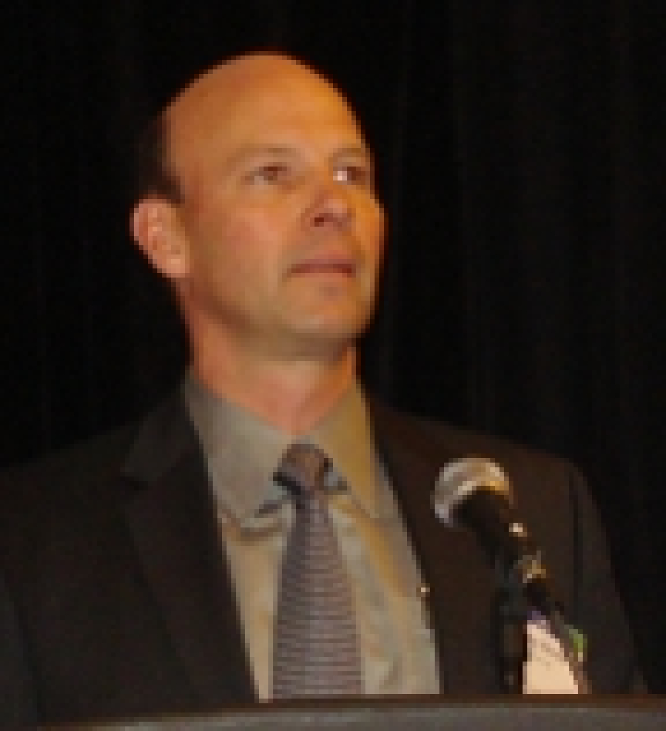 Photo of a man standing at a podium.