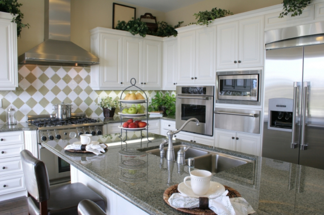 Photo of a modern kitchen, with appliances in the background and a counter / island in the foreground.