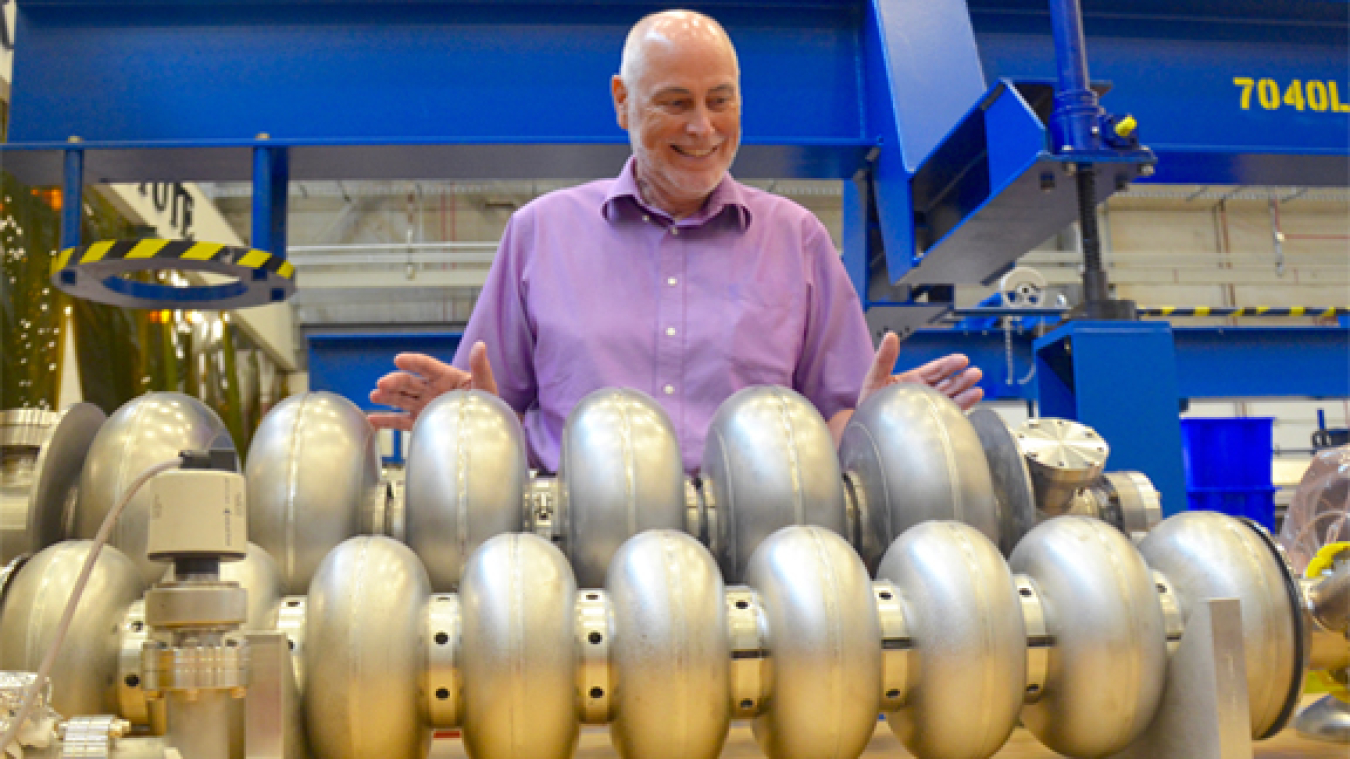 Andrew Hutton, associate director of Jefferson Lab's Accelerator Division, looks over prototype particle accelerating devices – called cavities – in the lab's Superconducting Radiofrequency Institute.