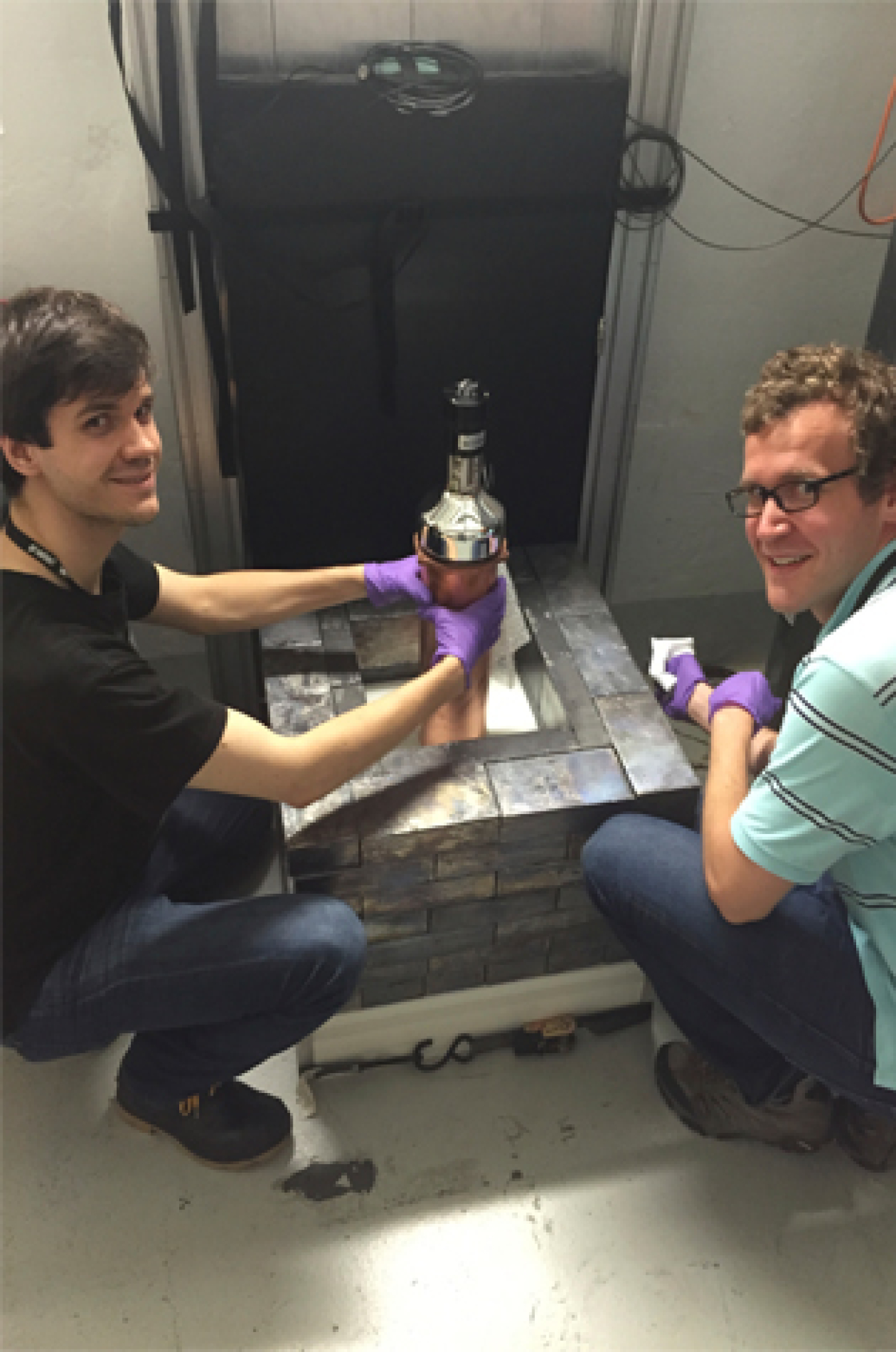 Bjorn Scholz (left) from the University of Chicago and Grayson Rich of the University of North Carolina at Chapel Hill and the Triangle Universities Nuclear Laboratory show off the world's smallest neutrino detector.