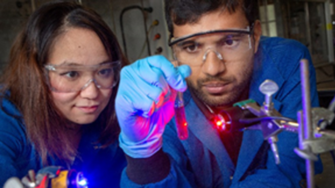 Researchers Yan Zhou (left) and Sahan Salpage (right) perform a photochemical separation of ruthenium and iron using blue and red light, respectively.