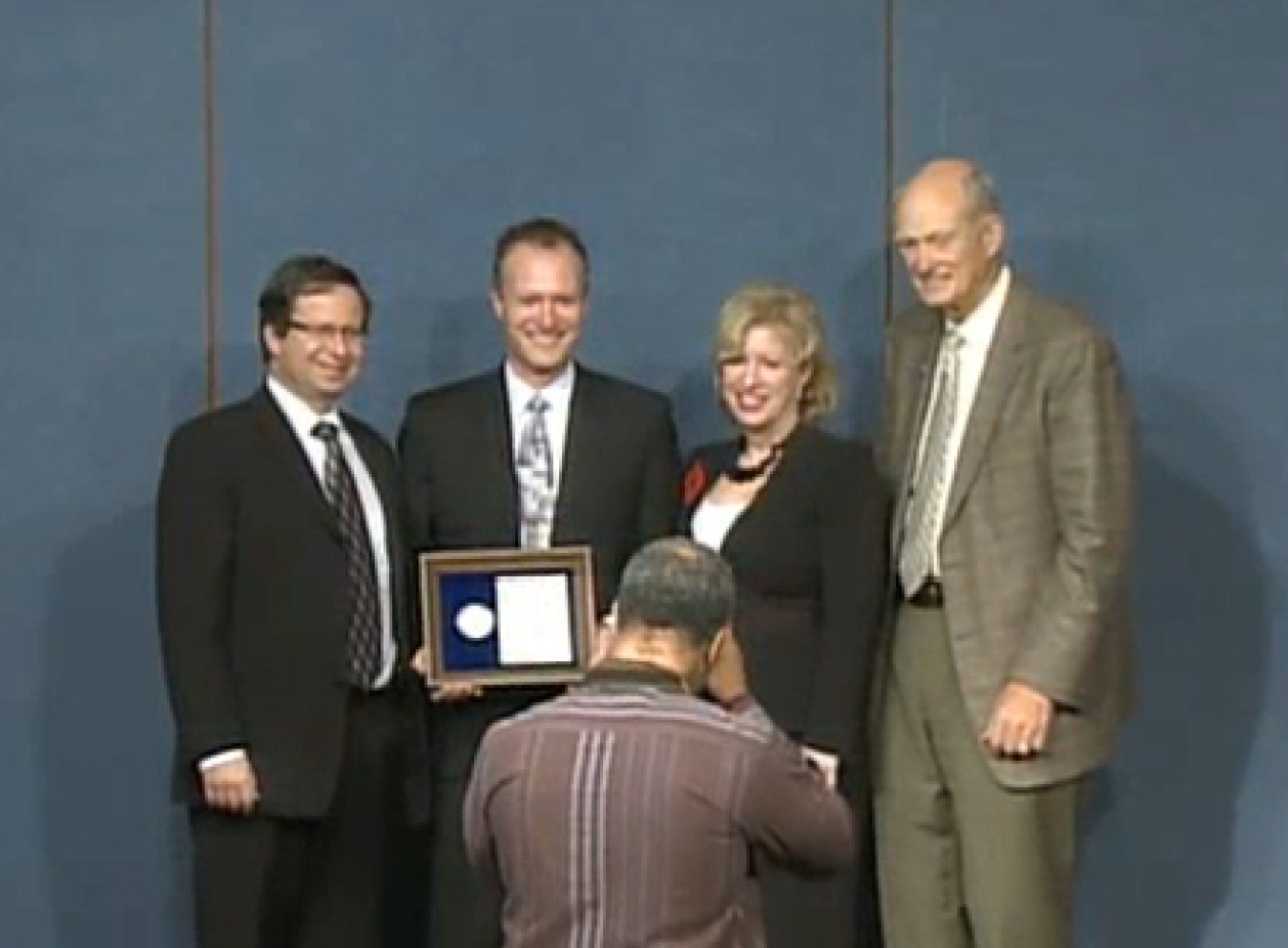 Senior leadership with a PECASE winner posing for a photograph
