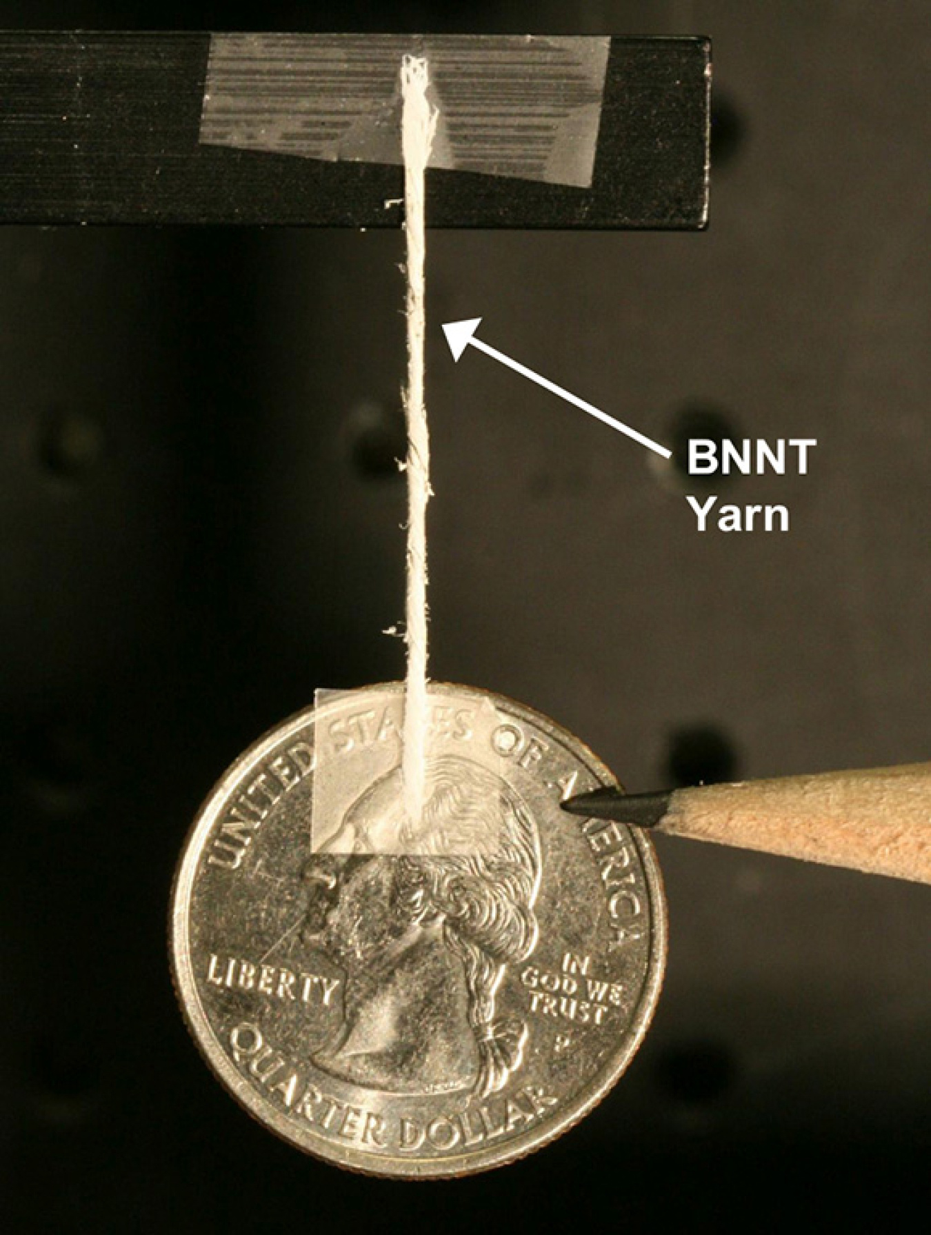 A yarn spun of boron-nitride nanotubes suspends a quarter.