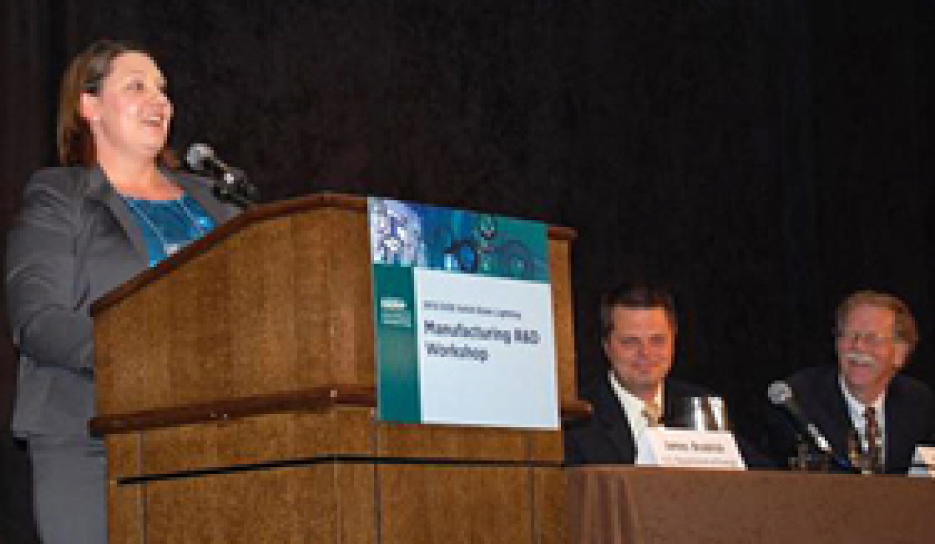 Photo of a woman standing behind a lectern, giving a presentation.