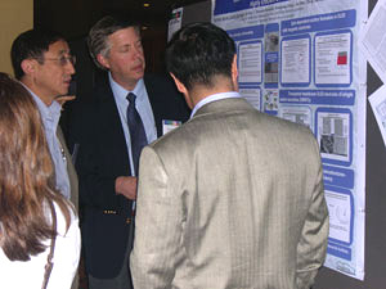 Photo of a group of people looking at a large poster.