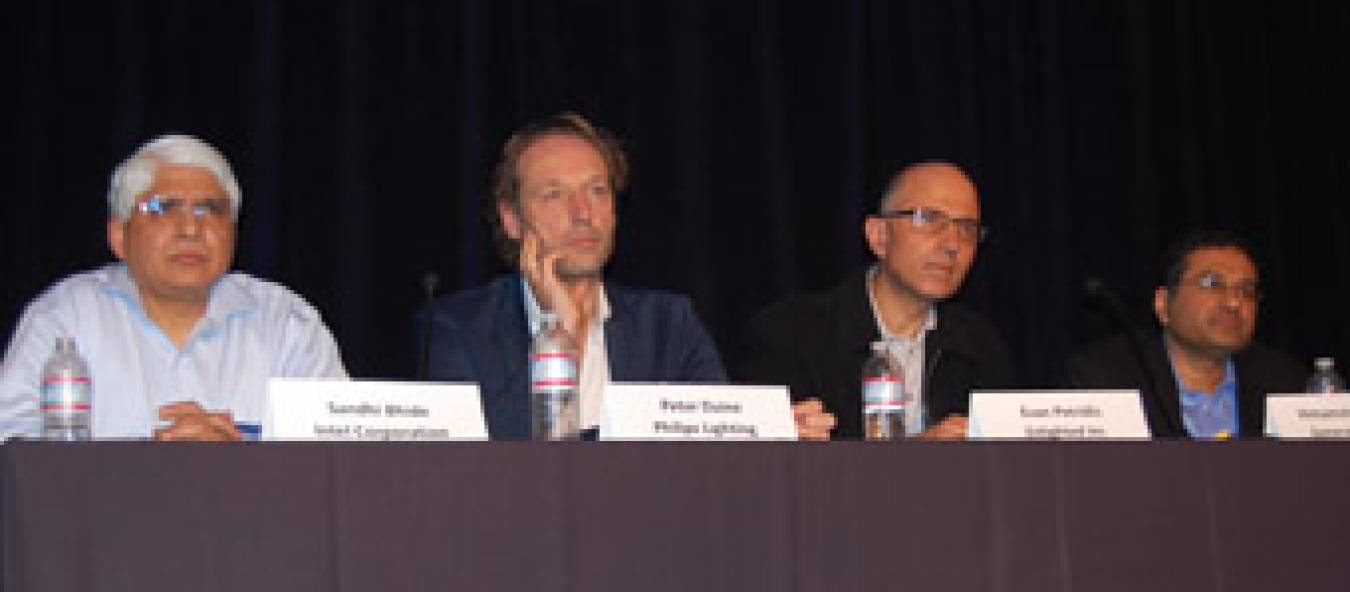 Four men seated at a table facing an audience.