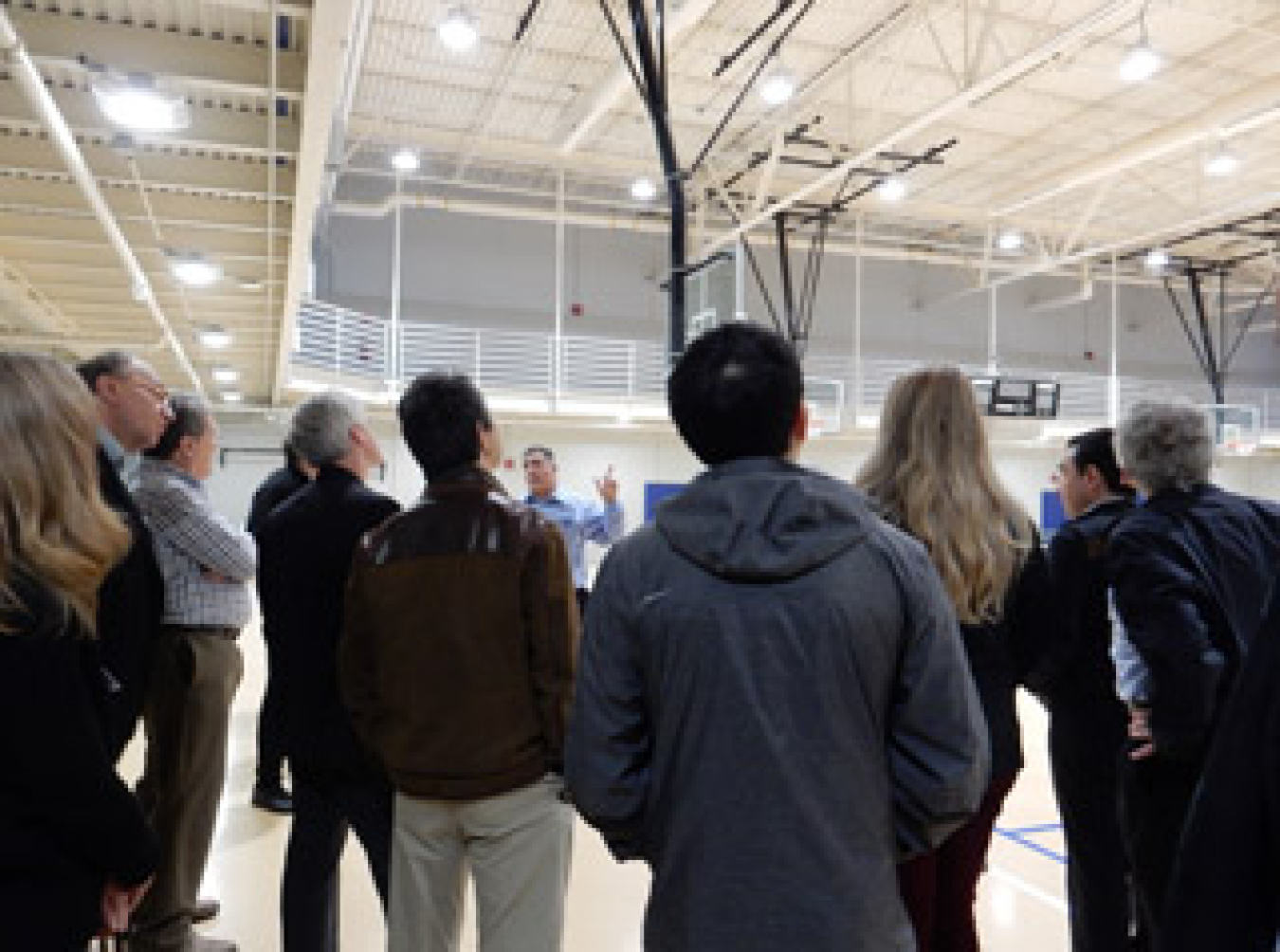 A group of people standing in a gymnasium.