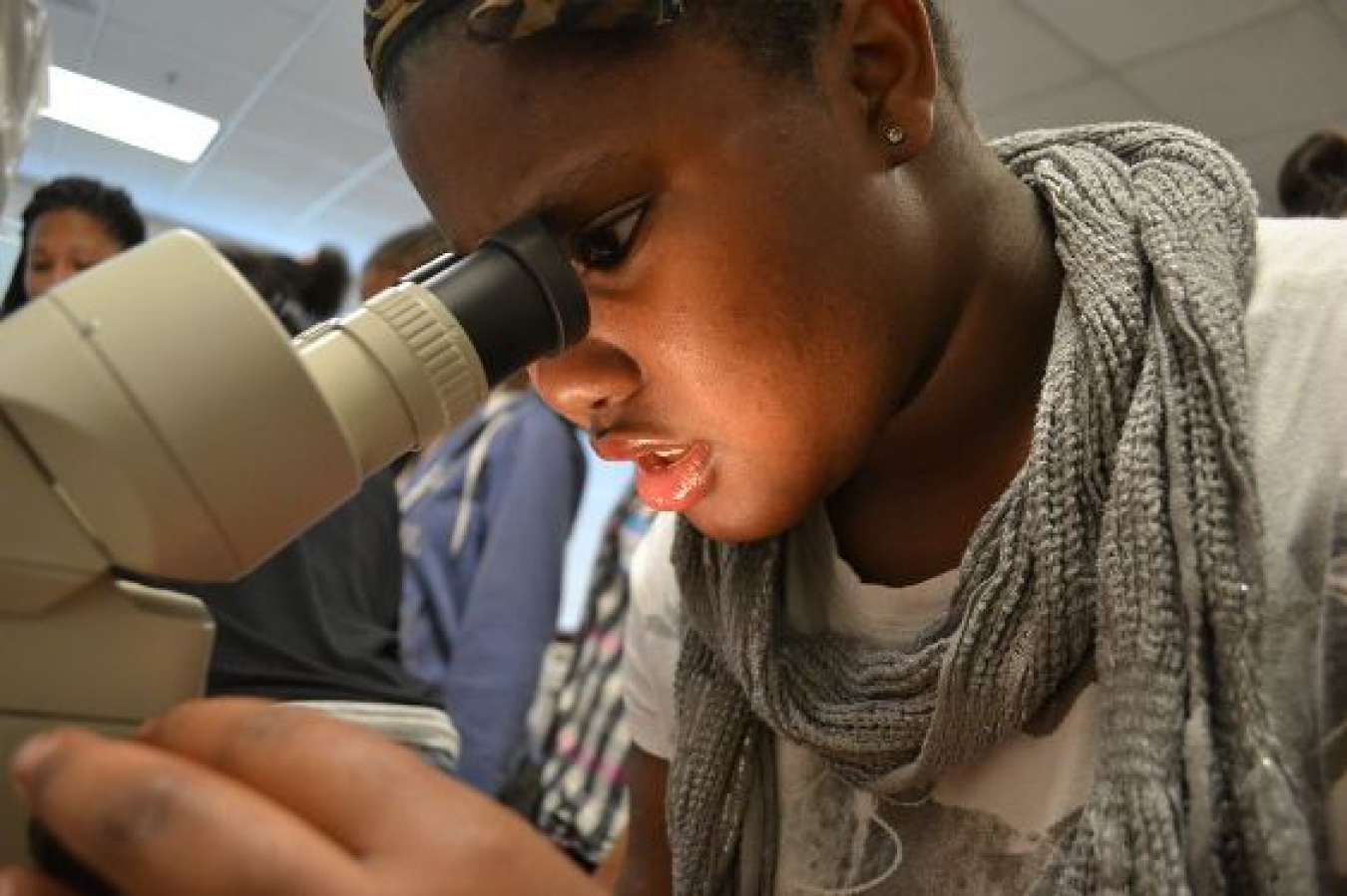 A female Spelman College student looks into a microscope