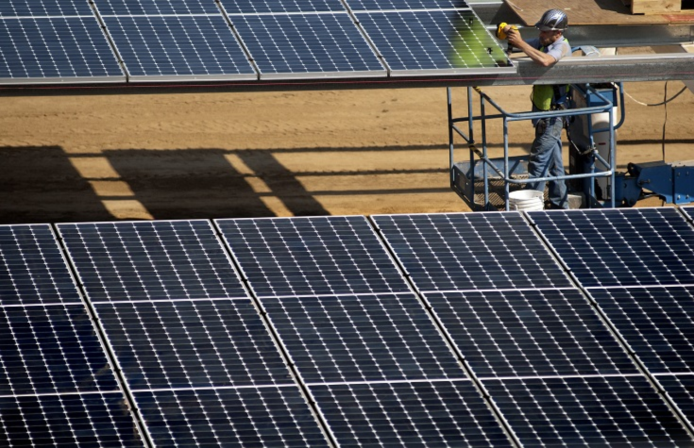 Workers install the parking lot solar panels at the University of California at Davis. 