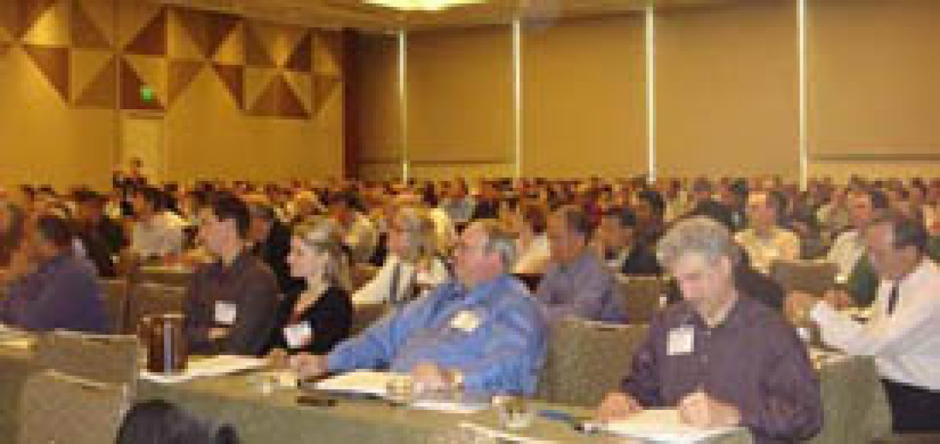 Photo of large audience seated in a conference room.