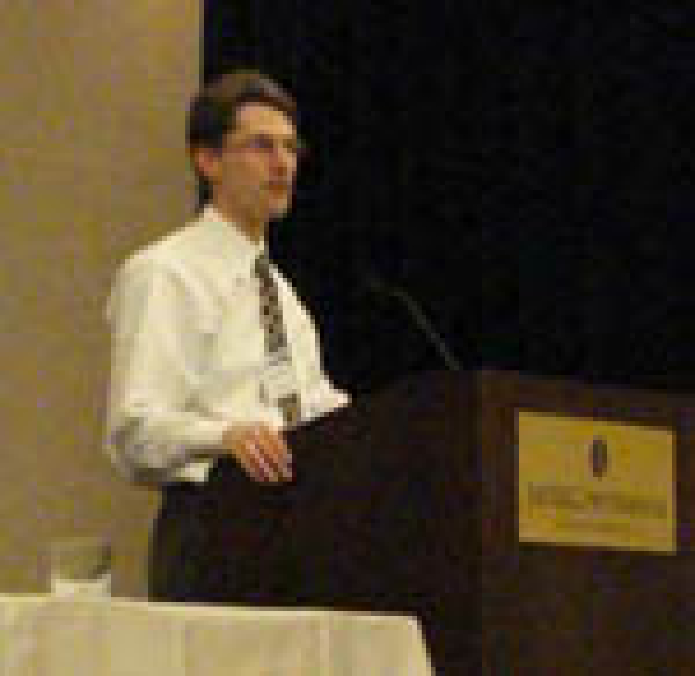 Photo of a man speaking at a podium.