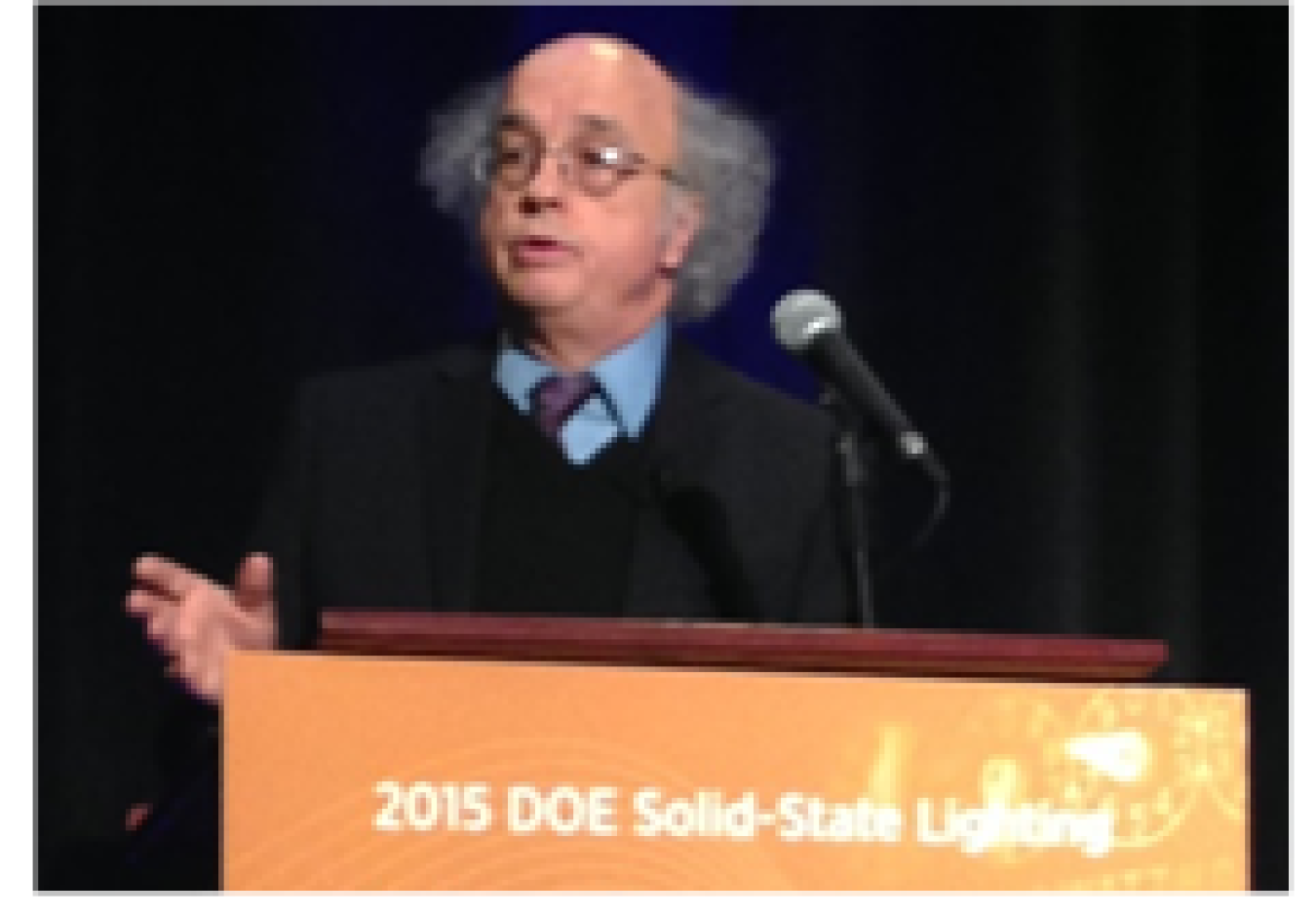 Man speaking at a lectern.