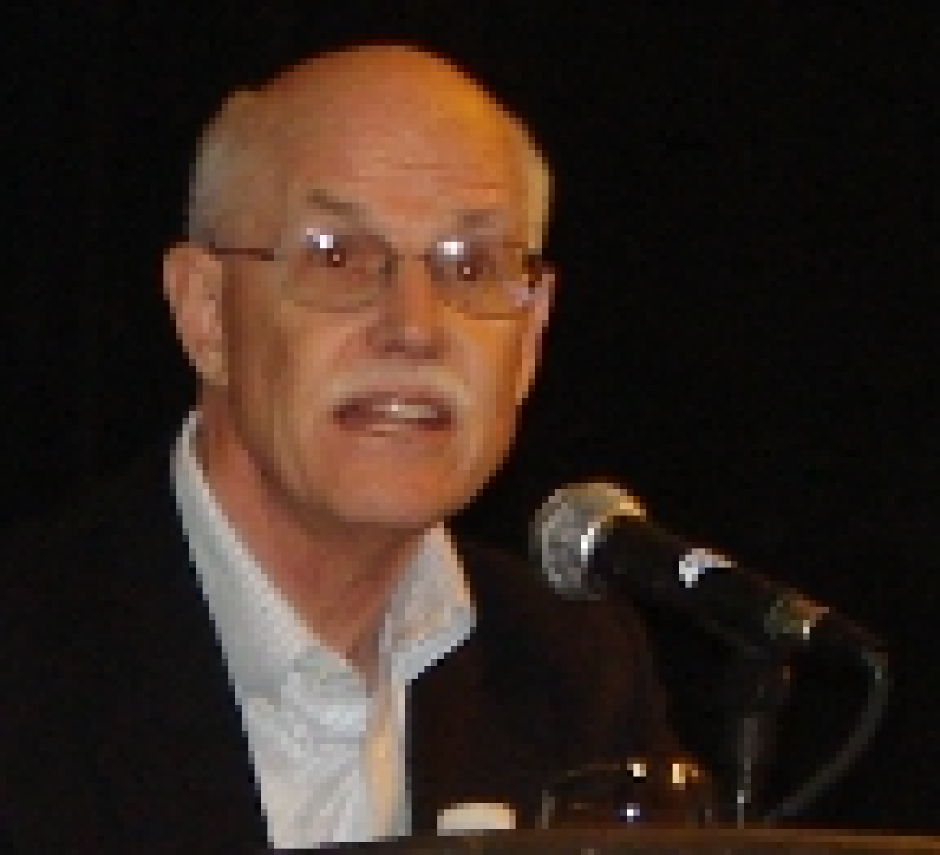 Photo of a man talking into a microphone.