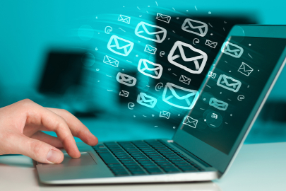 laptop with email icons bursting out of screen