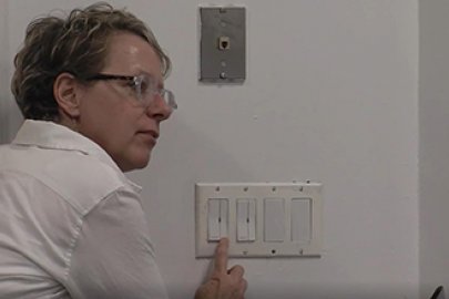 photo of a woman touching a light switch