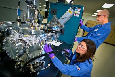 Female and male researchers conduct an experiment related to manufacturing