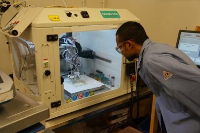 Man in a lab coat examining a machine: Heliotrope Technologies worked with Lawrence Berkeley National Laboratory (LBNL) under a Small Business Innovation Research Award.