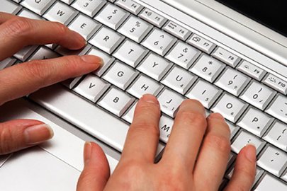 Hands typing on a keyboard.