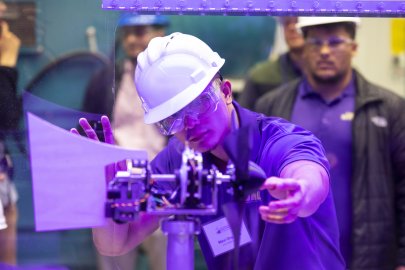 A student installs his team’s turbine in a wind tunnel for a test during the CWC 2019 Technical Challenge.