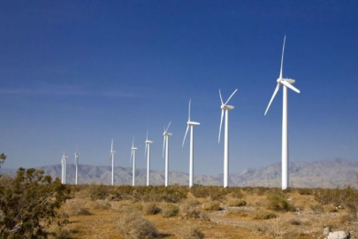 Wind turbines in an arid environment contrasted against a stark blue sky