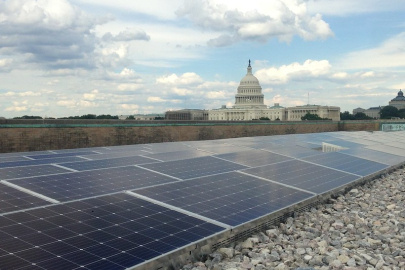 Solar panels on a government building roof with the U.S. Capitol in the background