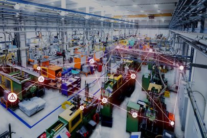 a photo of a manufacturing facility, with a digital network grid overlayed.